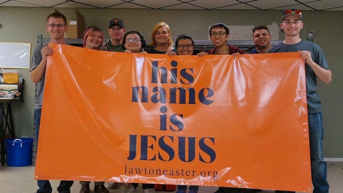 His Name is Jesus banner with volunteers